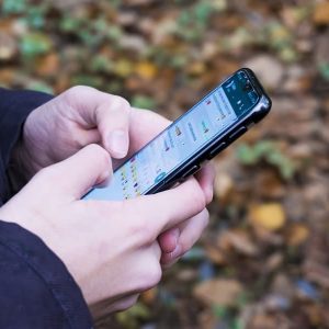 Persona usando su teléfono móvil para enviar un mensaje, representando contacto directo y comunicación cercana.